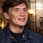 Cillian Murphy apparaît dans une interview, souriant et écoutant le journaliste. Il explique comment Barry Keoghan a décroché son rôle dans Peaky Blinders.