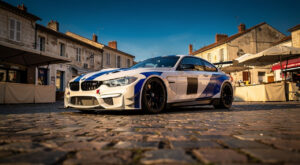 Arnold Robin sur le marché de La Ferté-Bernard avec la BMW n°72 avant la Road to Le Mans